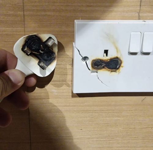 Burnt-out plug and socket removed from a customer's home — the damage was hidden behind the faceplate